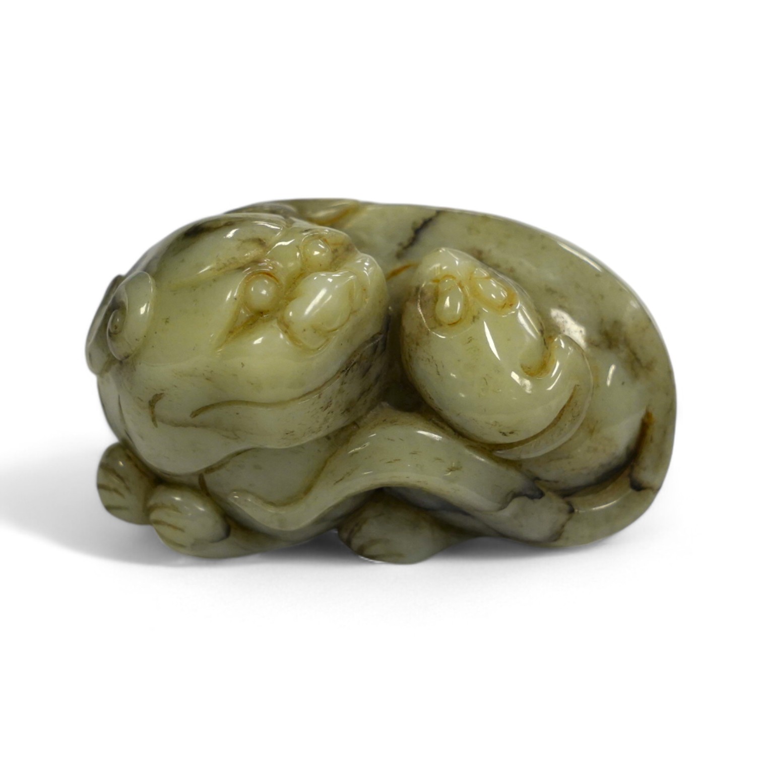 A Chinese jade figure of a lion-dog, 7.5cm wide, 4.3cm high. Condition - good